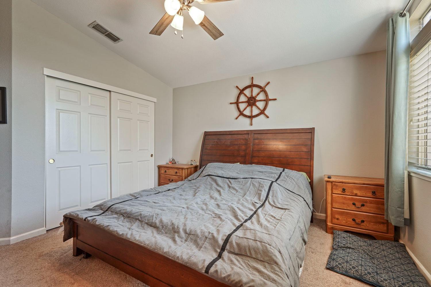 924 Dancer Way Turlock, CA 95382 - Photo 27 of 42 a bedroom with a bed and a chandelier