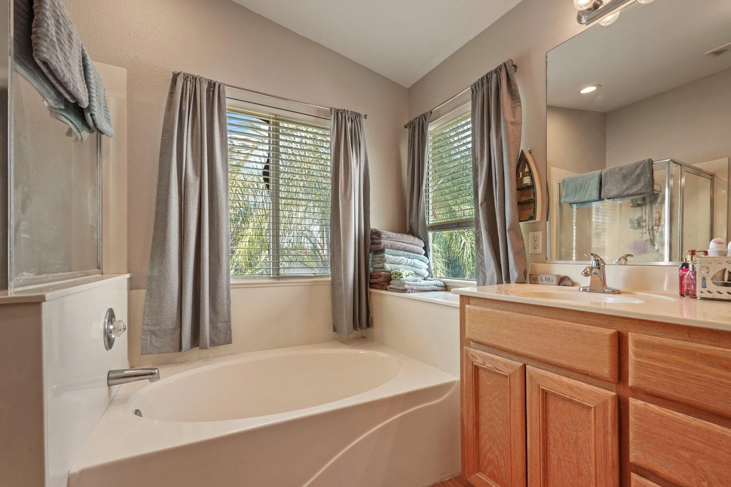 924 Dancer Way Turlock, CA 95382 - Photo 31 of 42 a bathroom with a tub sink and mirror