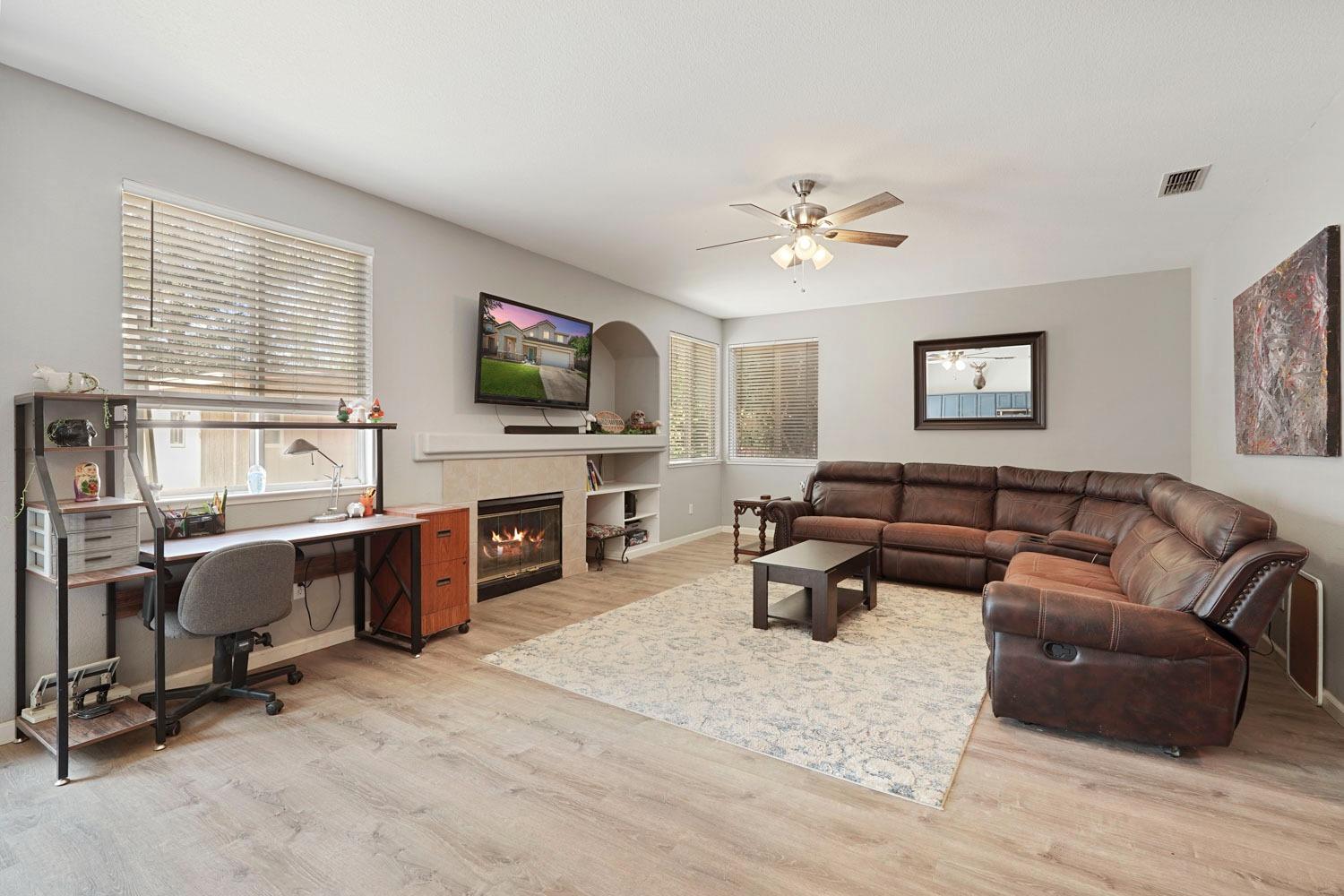 924 Dancer Way Turlock, CA 95382 - Photo 7 of 42 a living room with furniture a flat screen tv and a fireplace