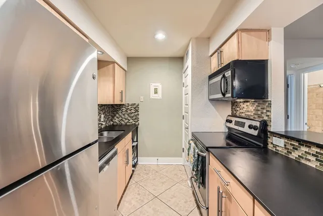 a kitchen with stainless steel appliances a stove microwave and a refrigerator