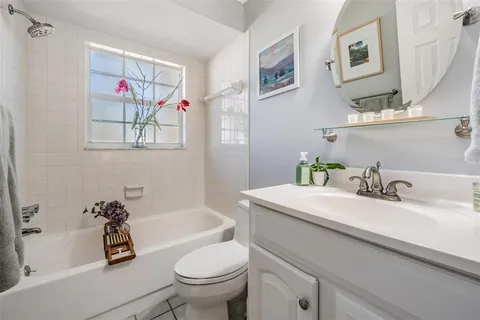 a bathroom with a sink mirror vanity and toilet