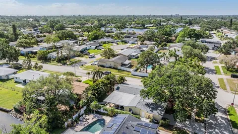 an aerial view of residential houses with outdoor space and trees