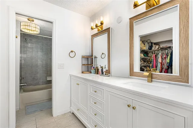 a bathroom with a granite countertop sink mirror and bathtub