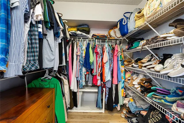 a view of walk in closet with clothes and shoes