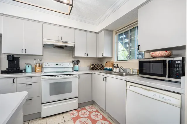 a kitchen with stainless steel appliances white cabinets and a sink
