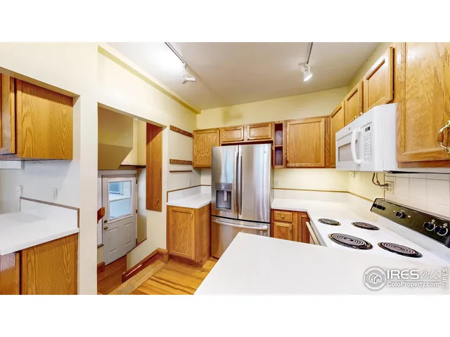 a kitchen with stainless steel appliances kitchen island granite countertop a refrigerator and a stove top oven