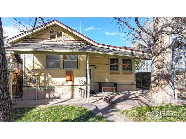 a backyard of a house with barbeque oven table and chairs