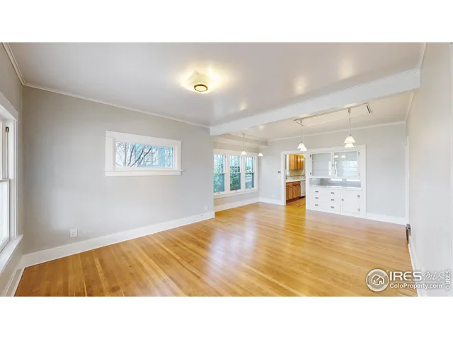 a open hall with wooden floor and windows
