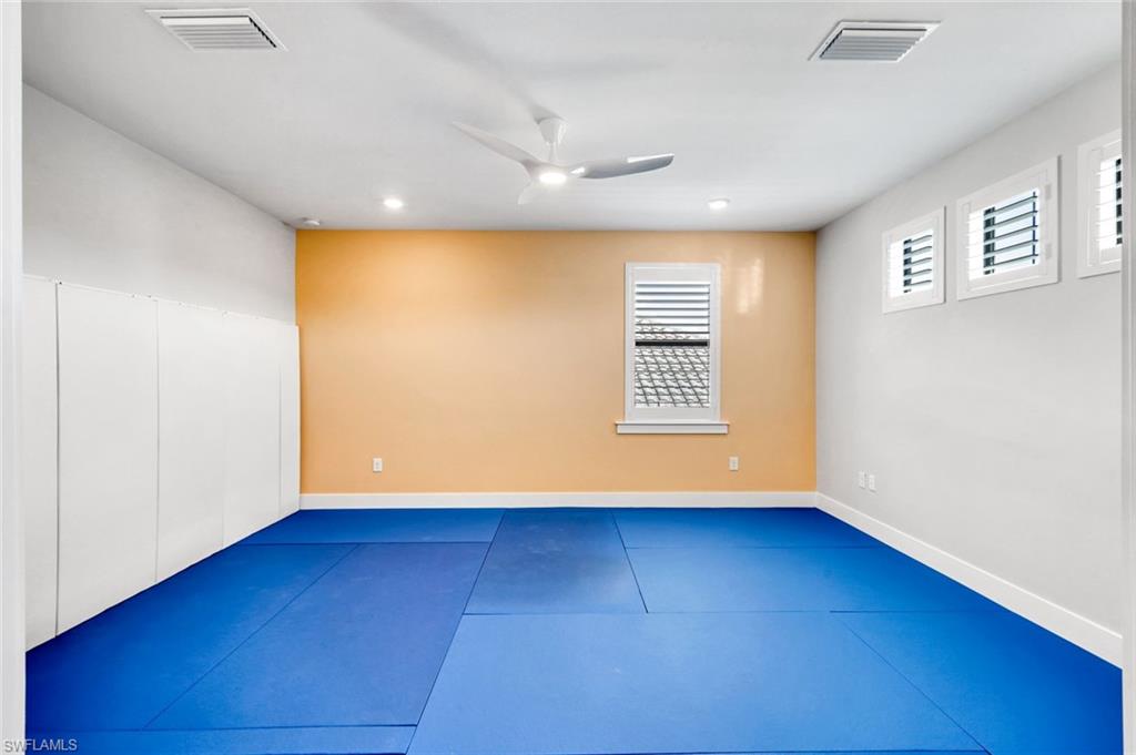 16249 Verilyn Circle Naples, FL 34110 - Photo 30 of 48 a view of an empty room with wooden floor and a window