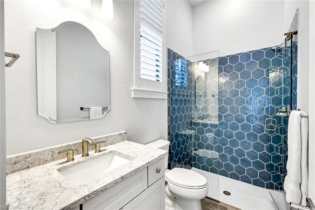 16249 Verilyn Circle Naples, FL 34110 - Photo 34 of 48 a bathroom with a granite countertop sink a toilet and a mirror