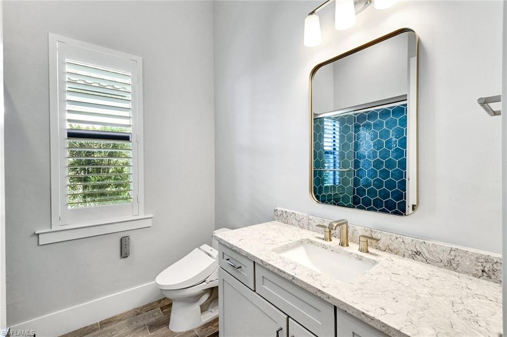 16249 Verilyn Circle Naples, FL 34110 - Photo 36 of 48 a bathroom with a granite countertop sink toilet and mirror