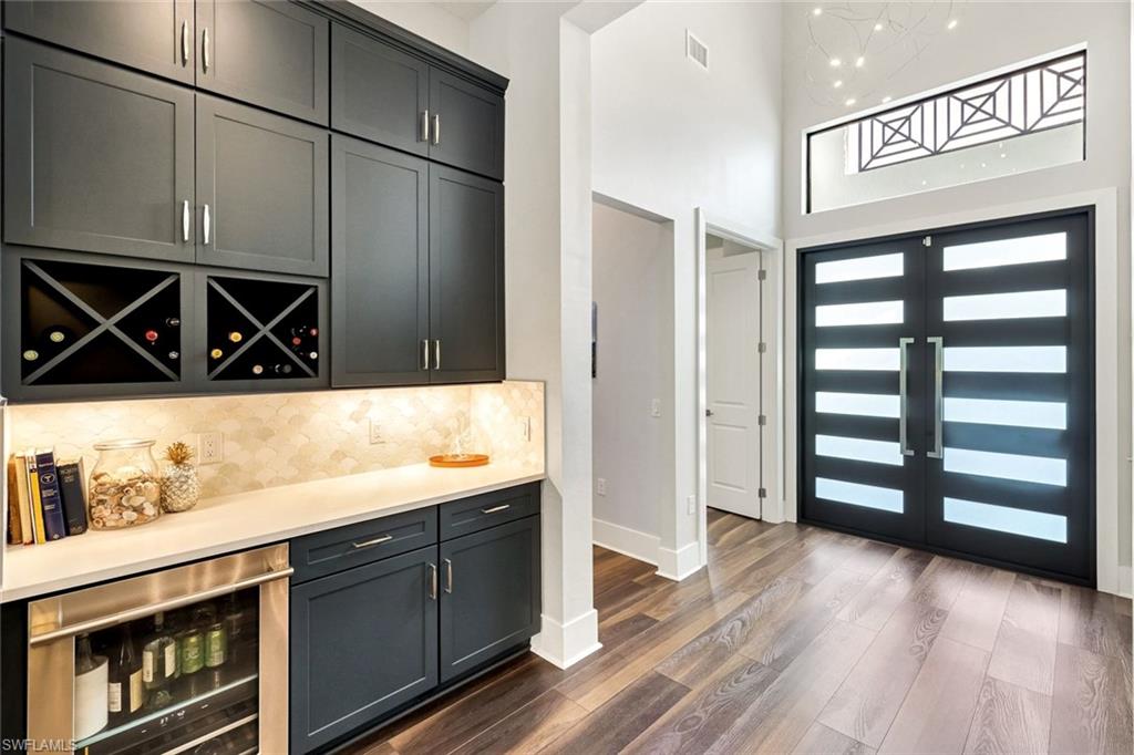 16249 Verilyn Circle Naples, FL 34110 - Photo 6 of 48 a kitchen with stainless steel appliances cabinets and a wooden floor