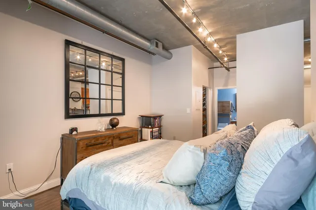 a bedroom with a bed and a painting on the wall