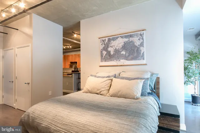 a bedroom with a bed and a painting on the wall