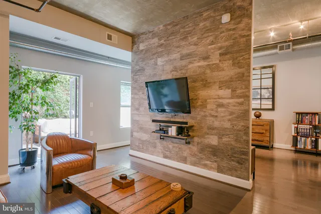 a living room with furniture a table and kitchen view