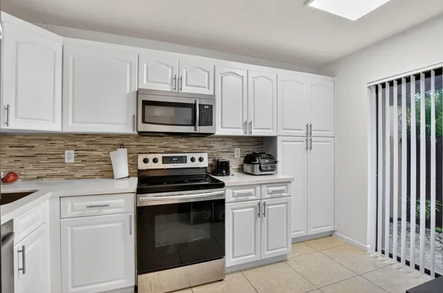 a kitchen with cabinets stainless steel appliances and sink