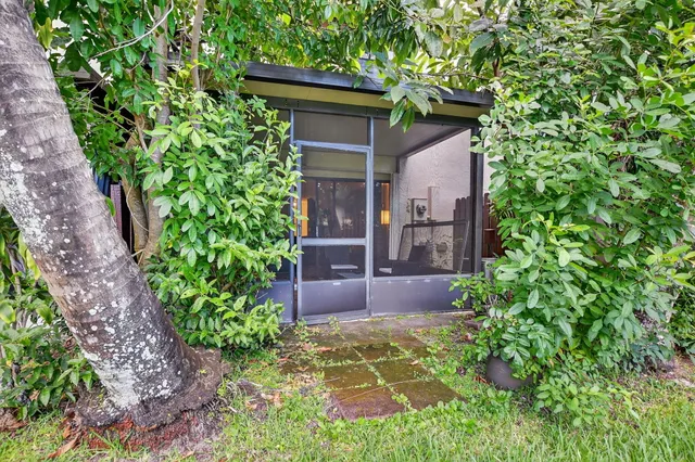 a view of a big house with a big yard and potted plants