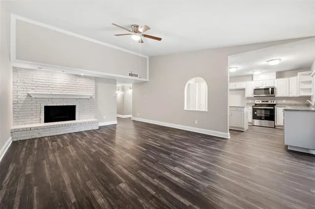 a view of empty room with wooden floor and fireplace