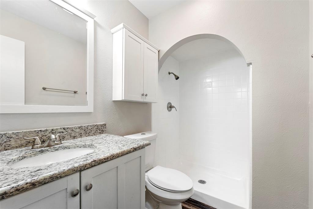 928 Overdowns Drive Plano, TX 75023 - Photo 7 of 11 a bathroom with a granite countertop sink a toilet and a shower