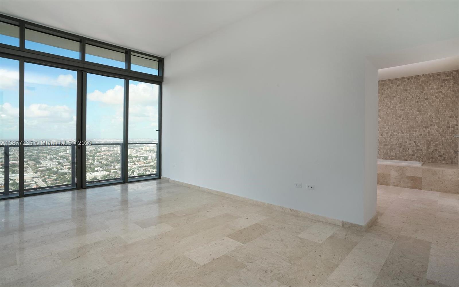 88 Southwest 7th Street, Unit 4001 Miami, FL 33130 - Photo 20 of 21 an empty room with wooden floor and windows with city view