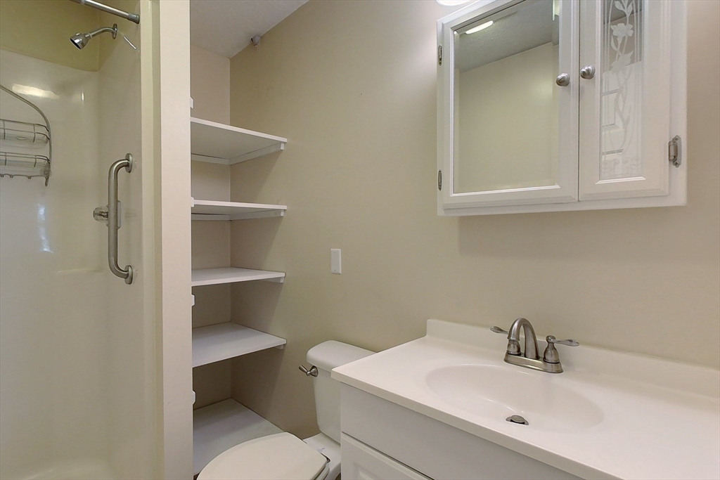 103 Main Street, Unit 10 Pepperell, MA 01463 - Photo 14 of 22 a bathroom with a sink toilet and vanity