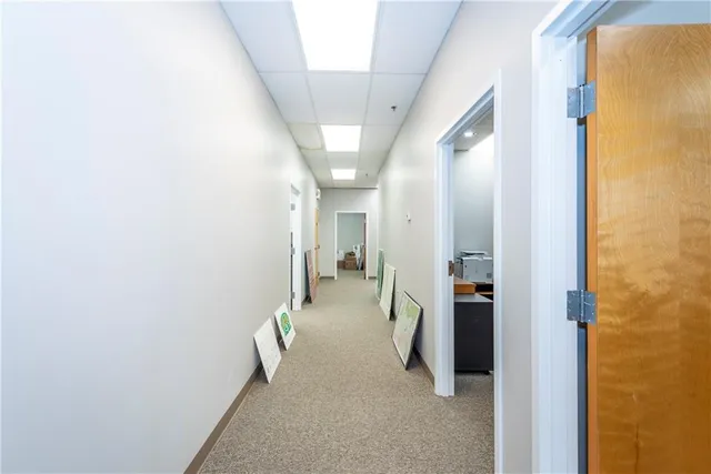 a view of a hallway with furniture and a bathroom
