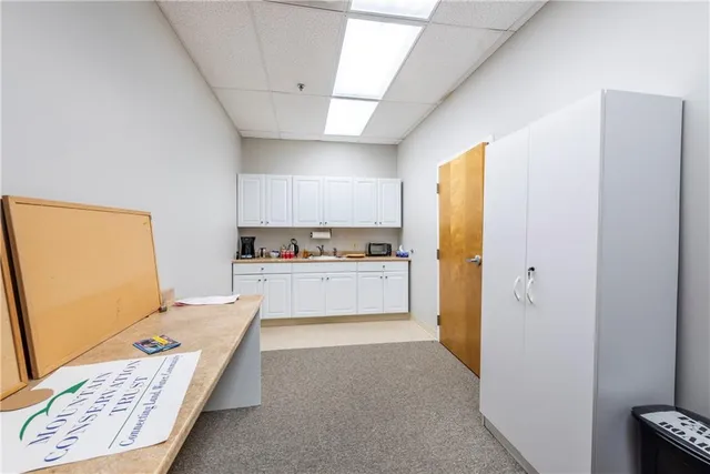 a kitchen with a refrigerator and white cabinets
