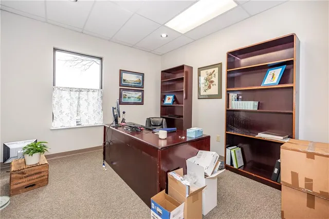 a work room with furniture a bookshelf and a window