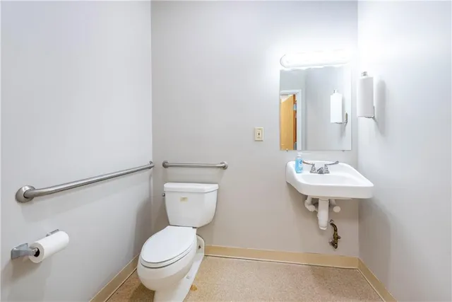 a bathroom with a toilet a sink and mirror