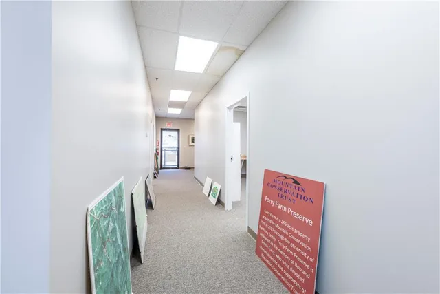 a hallway with stairs and wooden floor