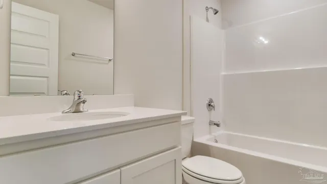 a bathroom with a bathtub shower sink vanity mirror and toilet