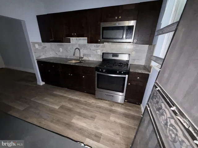 a kitchen with stainless steel appliances wooden cabinets and a stove