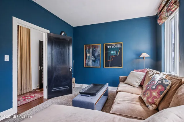 a living room with furniture and painting on the wall