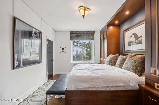 a bed sitting in a bedroom next to a window