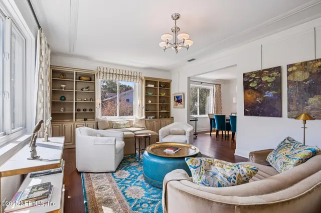 a living room with fireplace furniture and a large window