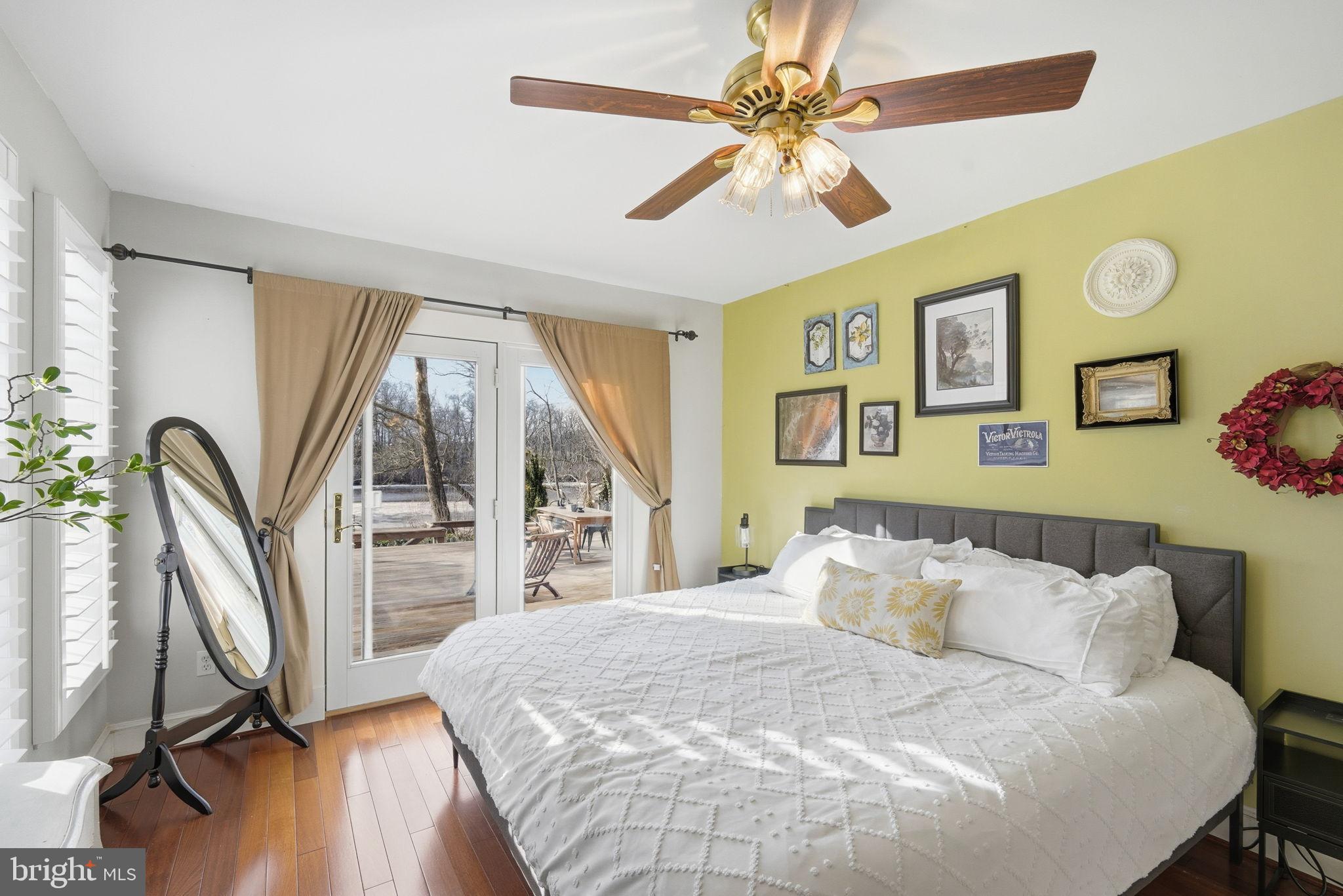 32135 River Road Millington, MD 21651 - Photo 13 of 33 a bedroom with a large bed and a chandelier