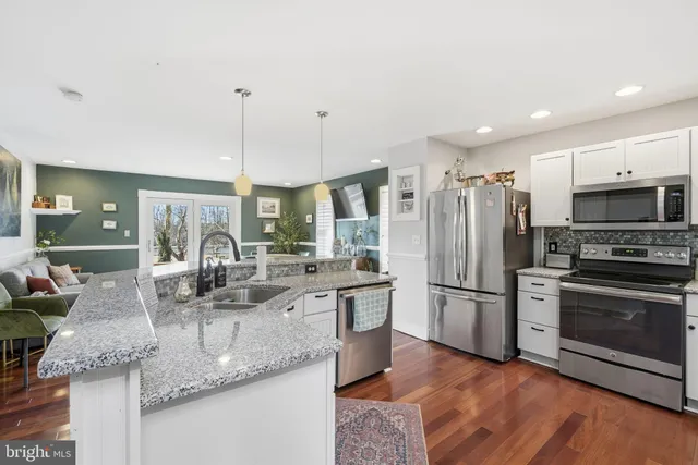 a kitchen with stainless steel appliances granite countertop a sink refrigerator and microwave