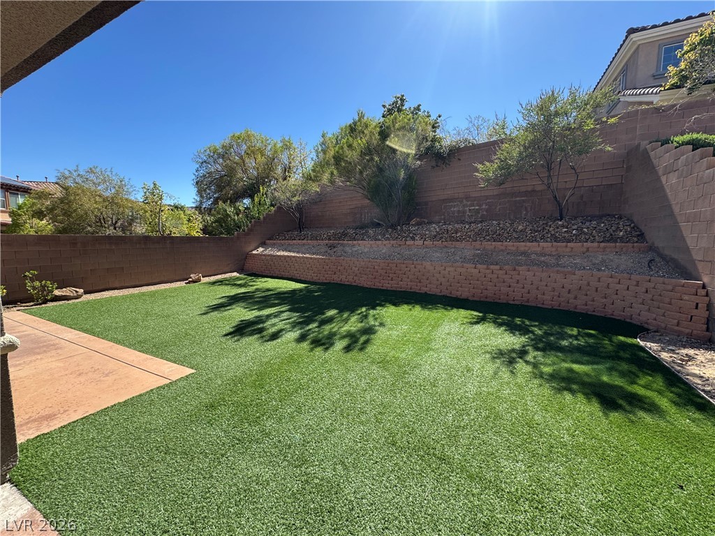 1333 Jamesbury Road Las Vegas, NV 89135 - Photo 22 of 43 A private, low-maintenance outdoor space features artificial turf and a multi-tiered retaining wall.
