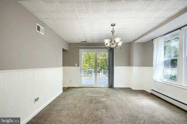 a view of a livingroom with a chandelier curtains and large windows