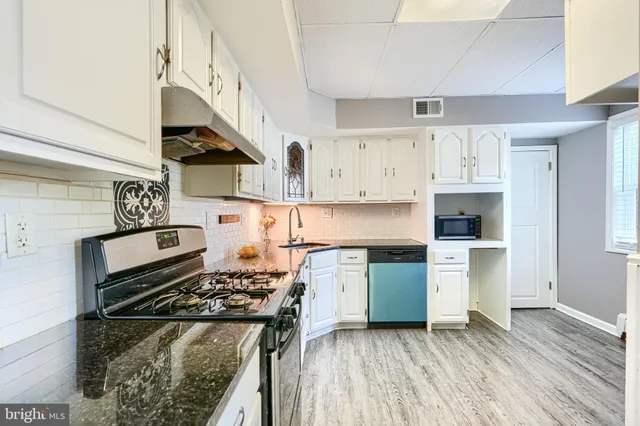 a kitchen with stainless steel appliances granite countertop a stove and a refrigerator