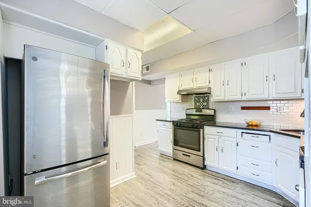 a kitchen with stainless steel appliances a refrigerator sink and cabinets