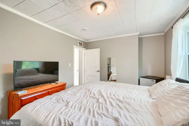 a bedroom with a bed and a flat screen tv