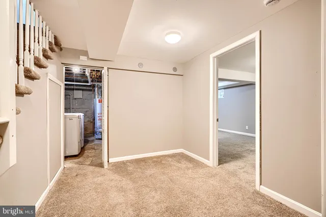 an empty room with an entryway and kitchen
