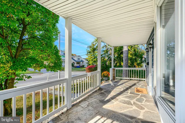 a porch with a bench next to a yard