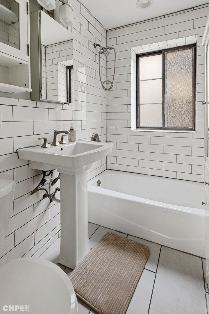7425 North Sheridan Road, Unit 1E Chicago, IL 60626 - Photo 11 of 31 a bathroom with a sink a toilet and bathtub