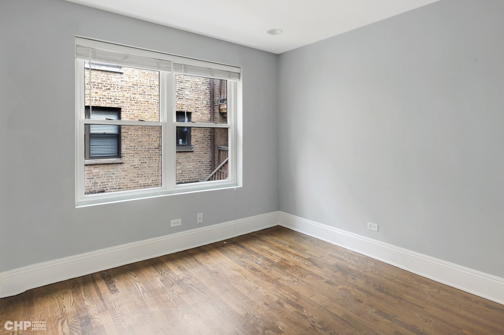 7425 North Sheridan Road, Unit 1E Chicago, IL 60626 - Photo 14 of 31 a view of an empty room with wooden floor and a window