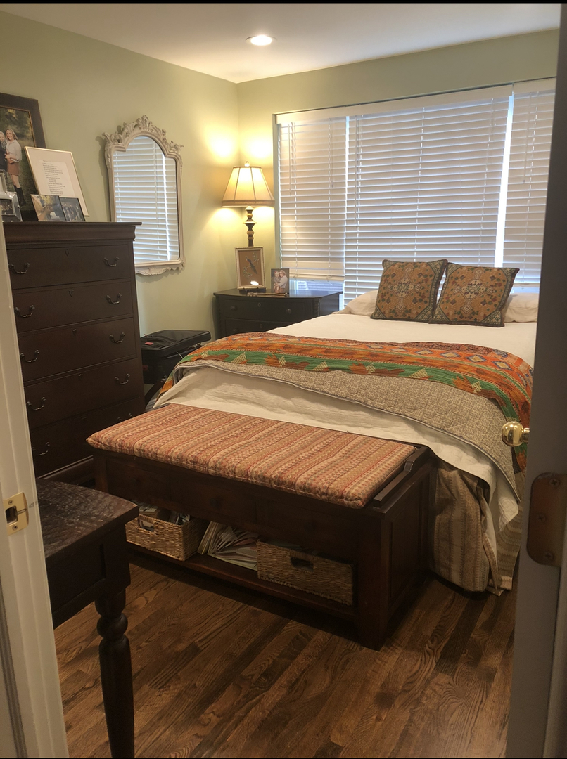 7425 North Sheridan Road, Unit 1E Chicago, IL 60626 - Photo 15 of 31 a bedroom with a bed and wooden floor
