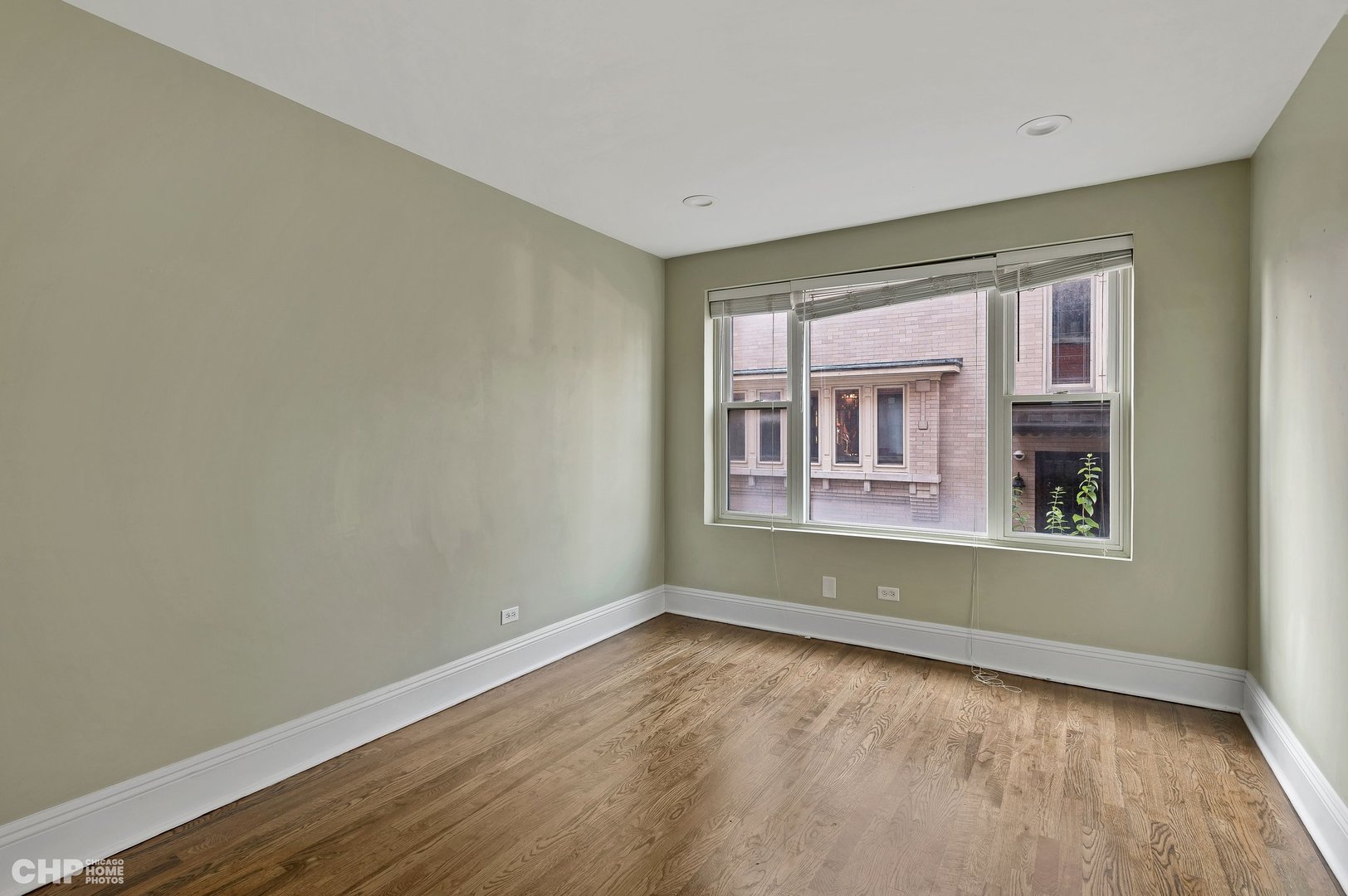7425 North Sheridan Road, Unit 1E Chicago, IL 60626 - Photo 18 of 31 a view of an empty room with wooden floor and a window