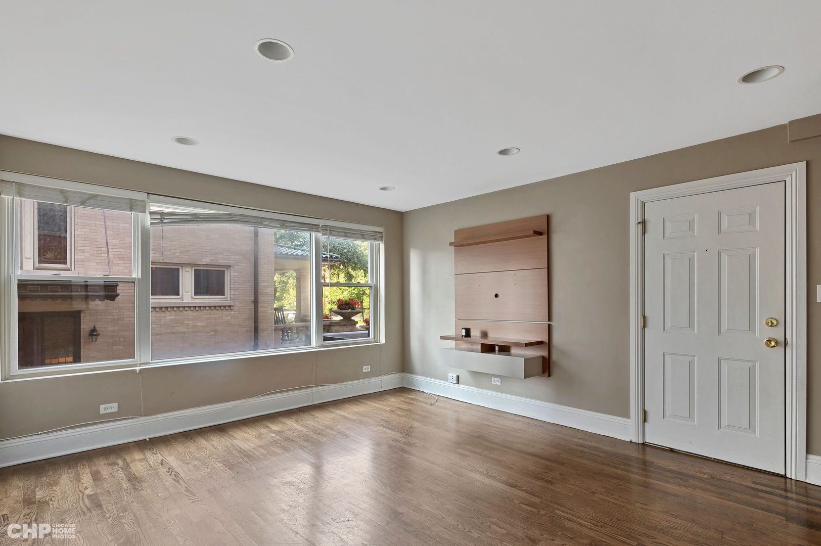7425 North Sheridan Road, Unit 1E Chicago, IL 60626 - Photo 2 of 31 a view of an empty room with a window and wooden floor