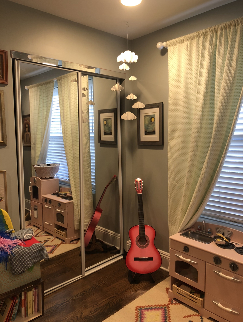 7425 North Sheridan Road, Unit 1E Chicago, IL 60626 - Photo 23 of 31 a bedroom with a bed and a chandelier